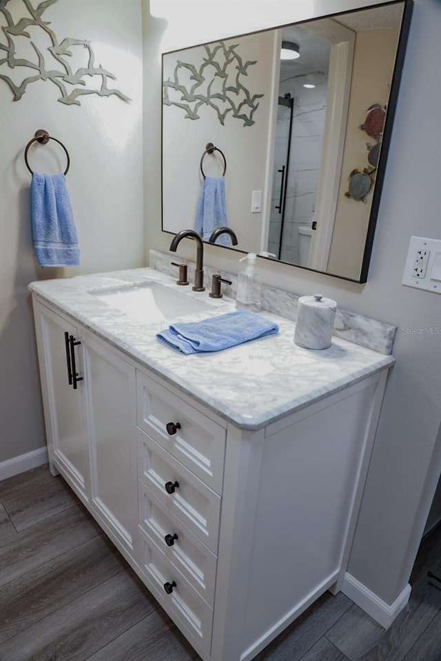 bathroom featuring a shower, wood-type flooring, and vanity