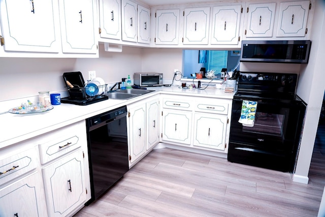 kitchen featuring white cabinets, sink, light hardwood / wood-style floors, and black appliances