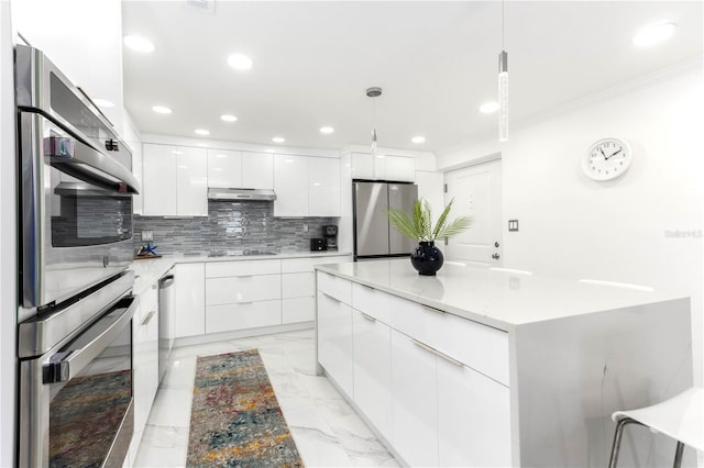 kitchen with tasteful backsplash, stainless steel appliances, white cabinets, a center island, and hanging light fixtures