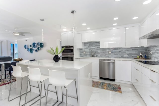 kitchen with white cabinetry, sink, decorative light fixtures, and appliances with stainless steel finishes