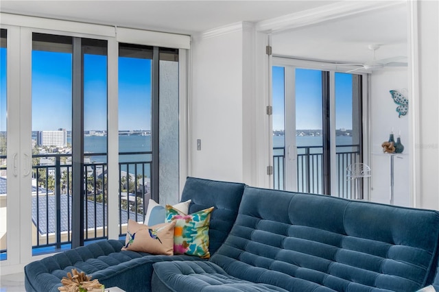 living room with expansive windows, a water view, and crown molding