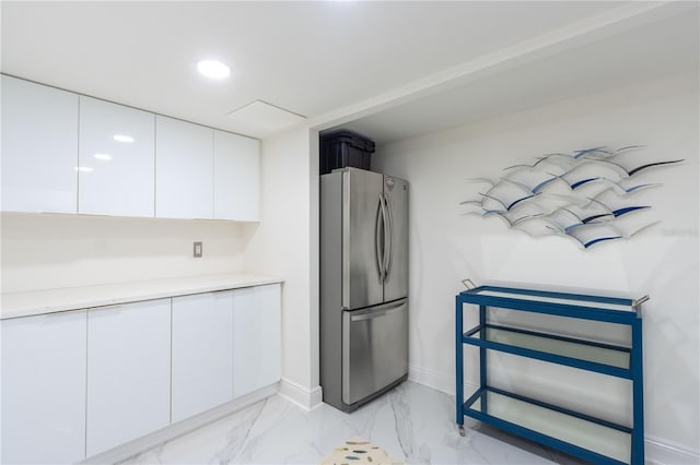 kitchen with white cabinets and stainless steel refrigerator