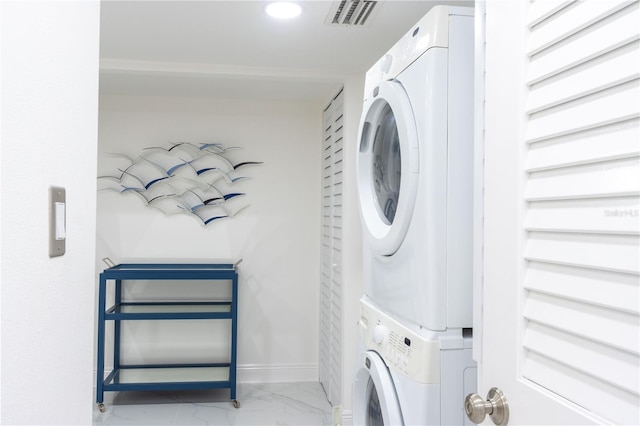 clothes washing area featuring stacked washer and dryer