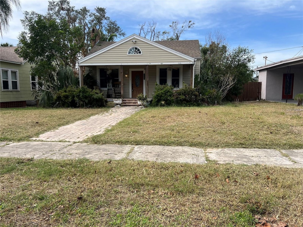 bungalow featuring a front lawn and covered porch