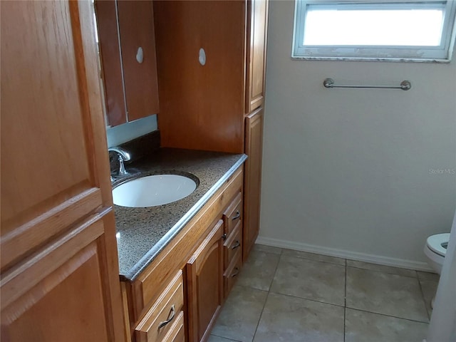 bathroom featuring tile patterned flooring, vanity, and toilet