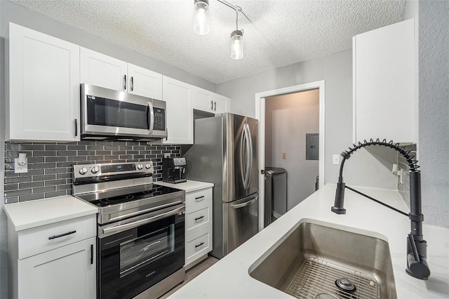 kitchen with white cabinets, stainless steel appliances, and light countertops