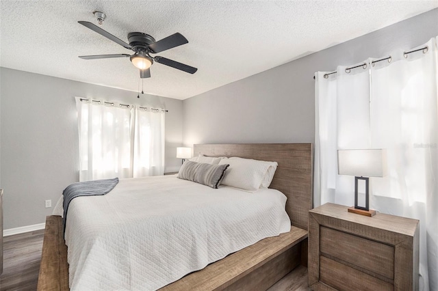 bedroom with dark wood-type flooring, ceiling fan, a textured ceiling, and baseboards