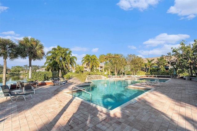 community pool featuring a patio and a water view