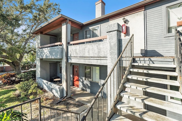 exterior space with a chimney and stucco siding