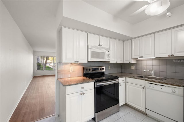 kitchen with white cabinetry, sink, tasteful backsplash, light hardwood / wood-style flooring, and white appliances