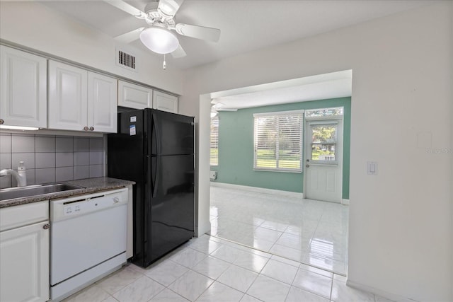 kitchen with white cabinets, dishwasher, black refrigerator, and backsplash