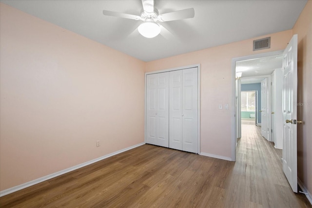 unfurnished bedroom featuring light wood-type flooring, a closet, and ceiling fan