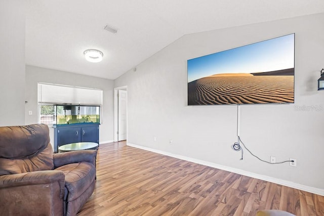 living room featuring hardwood / wood-style floors and vaulted ceiling