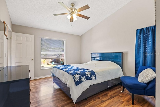 bedroom featuring a textured ceiling, vaulted ceiling, ceiling fan, and dark wood-type flooring