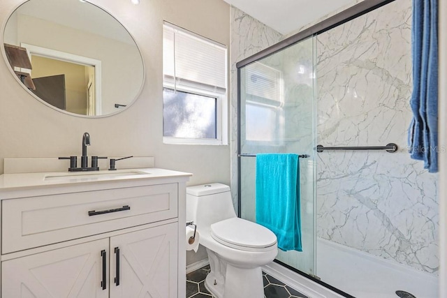 bathroom with tile patterned flooring, vanity, a shower with shower door, and toilet