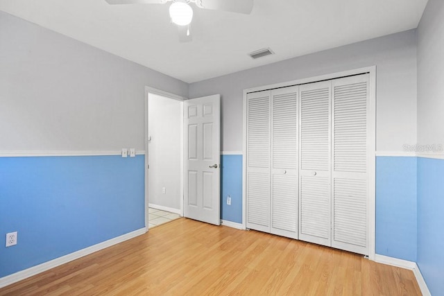 unfurnished bedroom with a closet, light hardwood / wood-style flooring, and ceiling fan