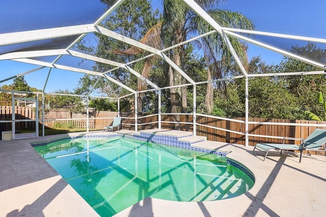 view of swimming pool with glass enclosure and a patio area