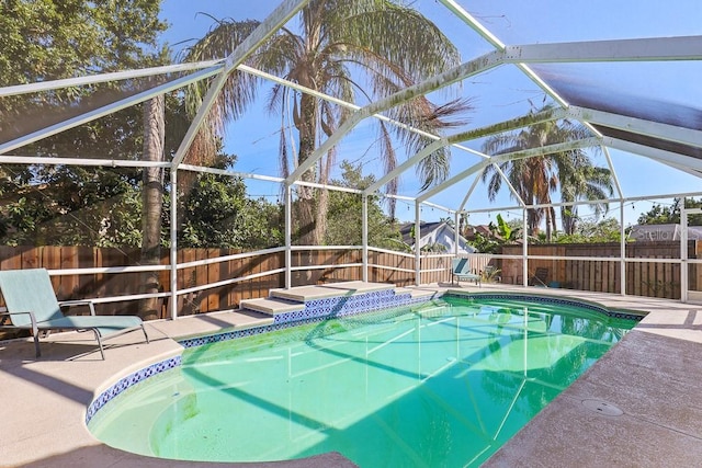 view of pool featuring glass enclosure and a patio