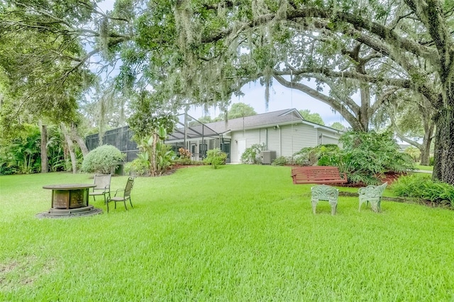 view of yard featuring a lanai and central AC unit