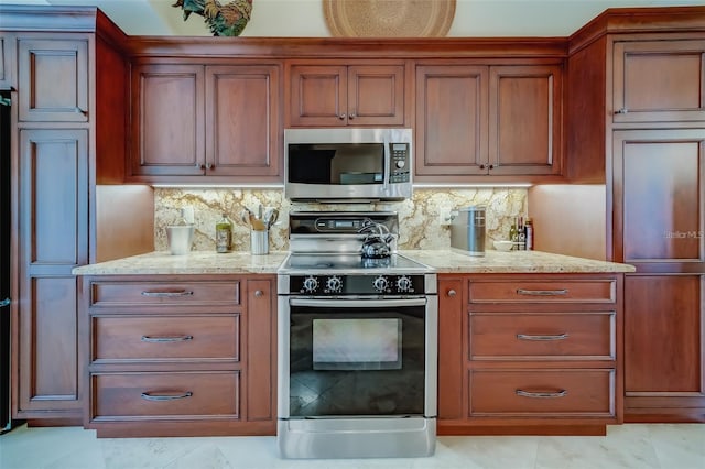 kitchen with light stone counters, stainless steel appliances, and backsplash