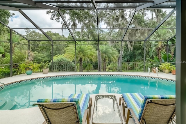 view of swimming pool featuring glass enclosure