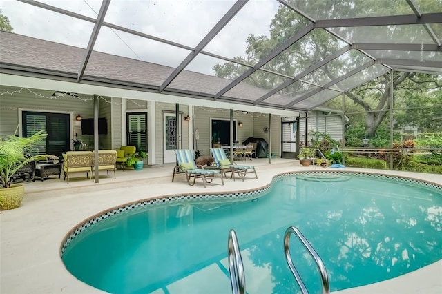 view of pool with glass enclosure, outdoor lounge area, and a patio