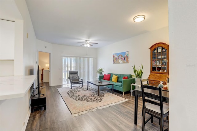 living room with ceiling fan and dark wood-type flooring