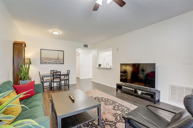 living room with ceiling fan and dark wood-type flooring