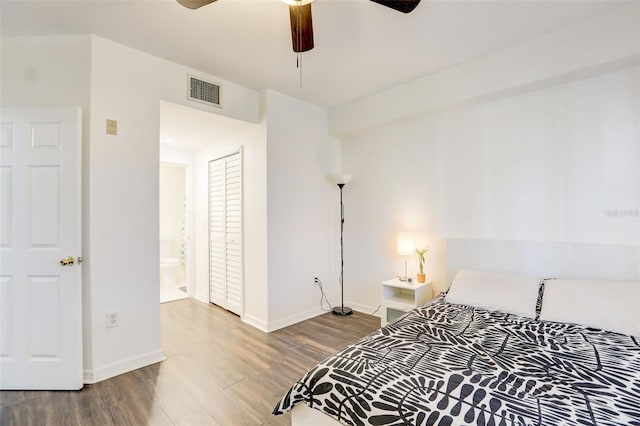 bedroom with hardwood / wood-style flooring, ceiling fan, and ensuite bath