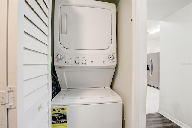 clothes washing area featuring stacked washer / drying machine and dark hardwood / wood-style floors