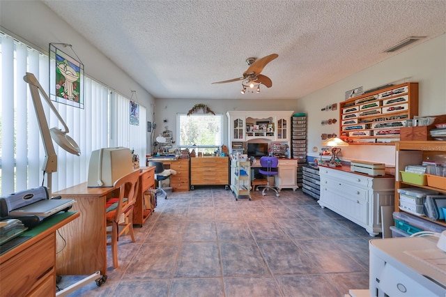 tiled office space with ceiling fan and a textured ceiling