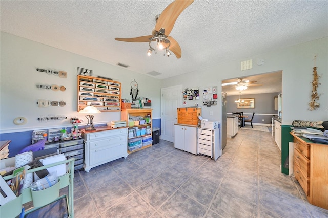 kitchen featuring a textured ceiling, white cabinetry, dark tile patterned floors, and ceiling fan