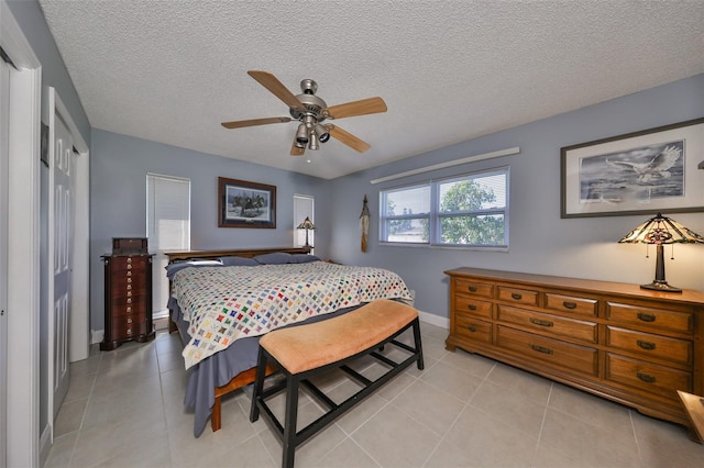 bedroom featuring light tile patterned floors, a textured ceiling, a closet, and ceiling fan