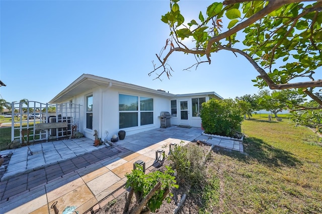 rear view of house with a patio area and a lawn