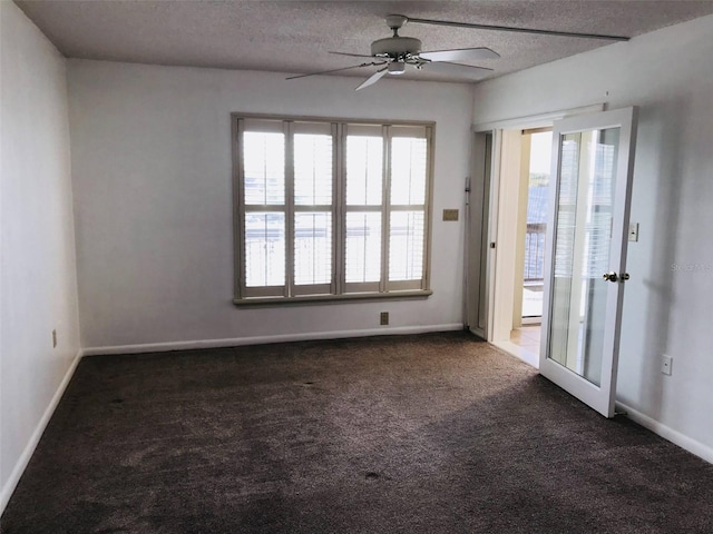 unfurnished room with dark colored carpet, ceiling fan, a textured ceiling, and a wealth of natural light