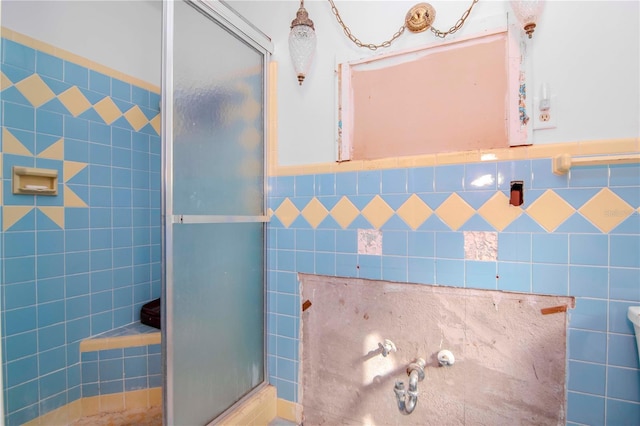 bathroom with a shower with door and tile walls