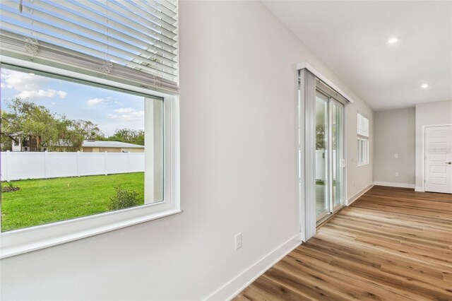 hall with baseboards, wood finished floors, and recessed lighting