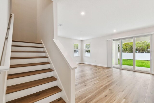 staircase featuring recessed lighting, baseboards, and wood finished floors