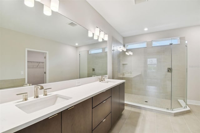 full bath with a stall shower, a sink, and a wealth of natural light