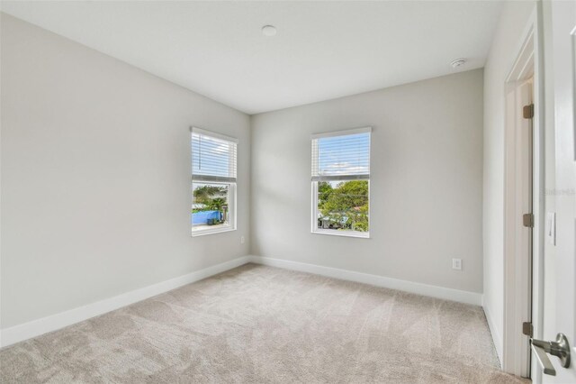 carpeted spare room featuring baseboards