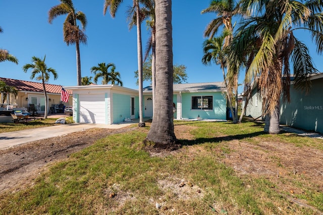 single story home featuring a front yard and a garage