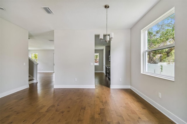 interior space featuring dark hardwood / wood-style floors, a wealth of natural light, and a notable chandelier