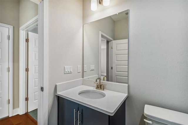 bathroom featuring vanity, toilet, and wood-type flooring