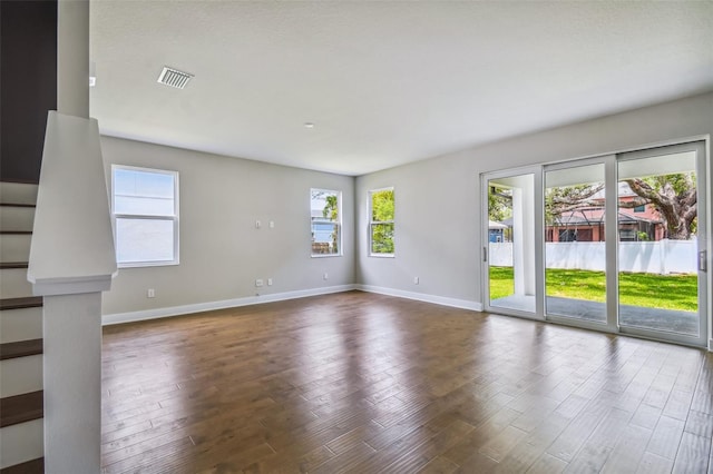 unfurnished room featuring a wealth of natural light and dark wood-type flooring