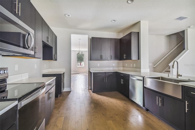 kitchen with sink, dark wood-type flooring, a textured ceiling, and appliances with stainless steel finishes