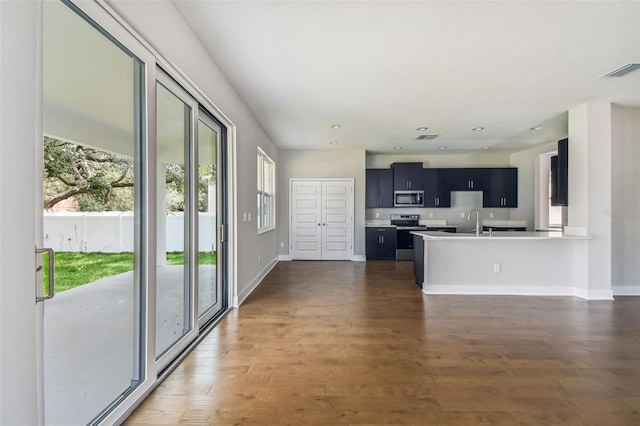 kitchen featuring kitchen peninsula, sink, dark wood-type flooring, and appliances with stainless steel finishes