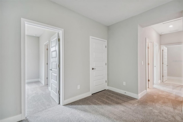 unfurnished bedroom with light carpet and ensuite bath