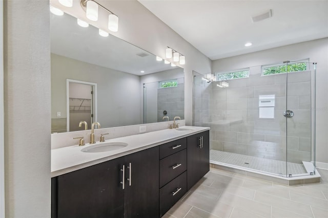 bathroom with tile patterned floors, vanity, and tiled shower