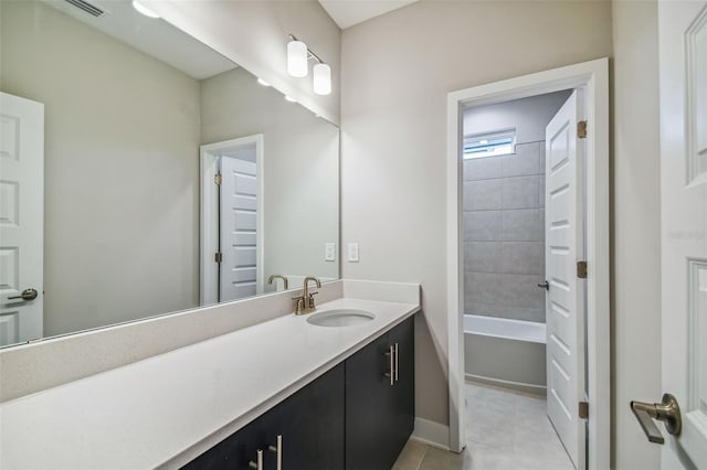 bathroom with tile patterned floors, vanity, and tiled shower / bath