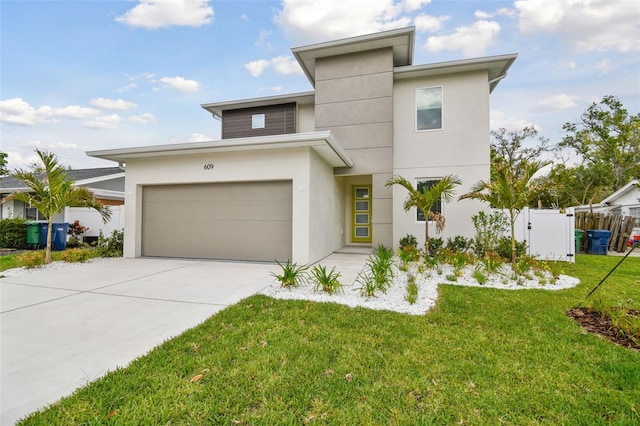 view of front facade with concrete driveway, a gate, fence, a front yard, and stucco siding